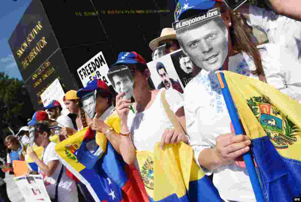 Con carteles y máscaras de presos políticos en Venezuela, venezolanos protestan en Washington.