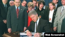 El presidente Bill Clinton promulga la Ley Helms-Burton. A su izquierda el congresista Bob Menendez y el senador Jesse Helms. 