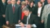 El presidente Bill Clinton promulga la Ley Helms-Burton. A su izquierda el congresista Bob Menendez y el senador Jesse Helms. 
