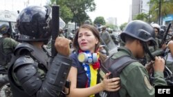 Una manifestante es detenida por miembros de la Guardia Nacional Bolivariana (GNB) durante una marcha hoy, en mayo de 2014, en Caracas (Venezuela). 