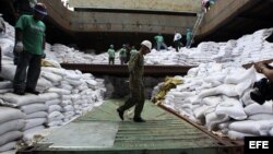  Un grupo de trabajadores desvela varios contenedores ocultos entre sacos de azúcar y que presumiblemente contienen material bélico, dentro del barco norcoreano Chong Chon Gang hoy, martes 16 de julio de 2013, en el muelle de Manzanillo en Colón (Panamá).