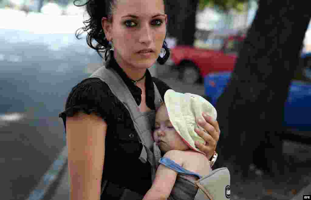 Una mujer carga a su pequeño hijo en La Habana (Cuba)agosto de 2014. Para el año 2030 o quizás antes&nbsp;la población de Cuba baje de 11 millones de habitantes, de un aproximado actual de 11 millones 167 mil.