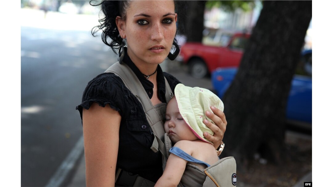 Una mujer carga a su pequeño hijo en La Habana, agosto de 2014.