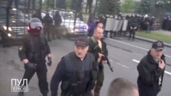 El presidente bielorruso, Alexander Lukashenko, armado y protegido con chaleco antibalas, camina fuera del Palacio de la Independencia en Minsk, el domingo 23 de agosto de 2020.