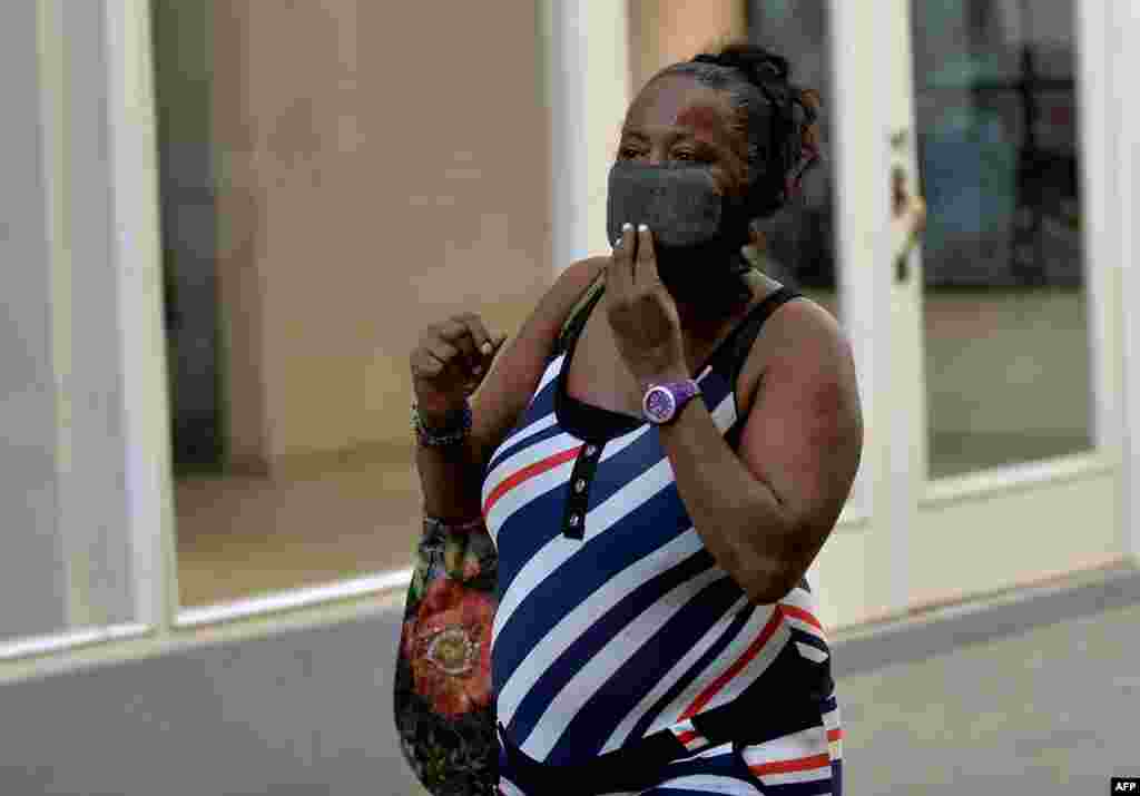 Una mujer cubana con una m&#225;scara protectora camina por una calle de La Habana.