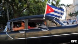  Un viejo taxi con una bandera cubana.
