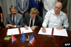 Herve Conan (C) de la Agencia Francesa de Desarrollo y el ministro cubano de Inverisón Extranjera Rodrigo Malmierca firman un acuerdo en 2017.