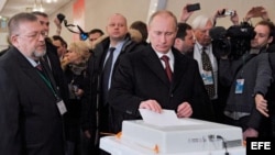 El actual primer ministro y candidato presidencial, Vladímir Putin (c), vota en un colegio electoral en Moscú. 
