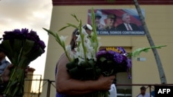 Una mujer lleva flores a San Lázaro, en El Rincón, La Habana. (Yamil Lage/AFP/Archivo)