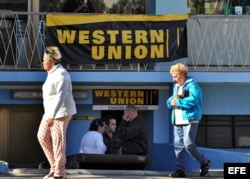 Un grupo de personas hace fila en una oficina de Western Union en La Habana.