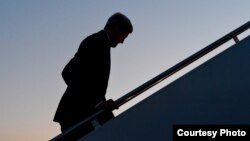 John Kerry sube las escaleras del avión que le lleva a Cuba.