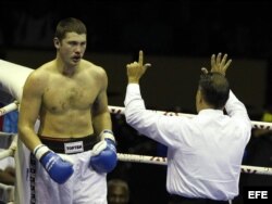 El árbitro hace un conteo de protección al boxeador ruso Dmitry Zaytsev (izq), antes de detener el combate con el cubano Erislandy Savón.