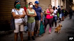 Cubanos hacen fila para comprar alimentos.