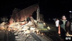 Un grupo de personas permanece a las afueras de una casa destruida en la localidad de Nagarote, 30 kilómetros al occidente de Managua.