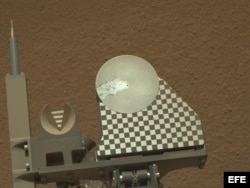 El brazo del robot Curiosity entrega una muestra de suelo marciano a la bandeja de observación del rover durante el 70 día de la misión marciana.