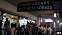 Varias personas hacen cola para comprar computadoras, o simplemente curiosear, en una tienda de La Habana.