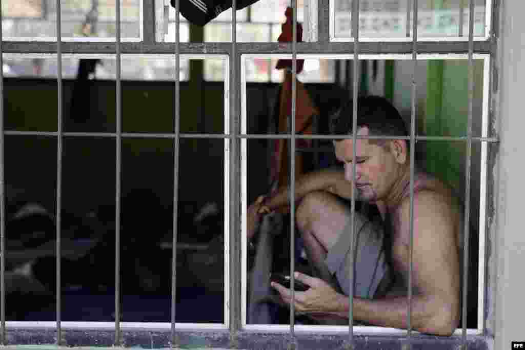 Un cubano observa su celular en uno de los albergues ubicados en el pueblo de La Cruz, Costa Rica. EFE