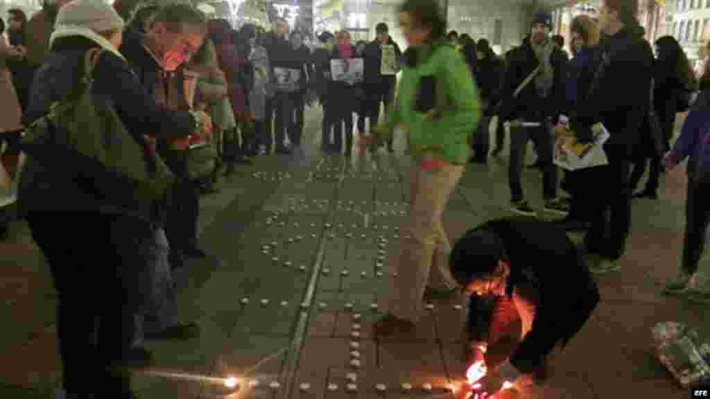 Forman en el suelo con velas la palabra "Charlie" ante la sede del Parlamento Europeo en Bruselas