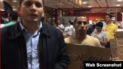 Eliécer Ávila (izquierda) protesta junto a otros miembros de Somos+ en el Aeropuerto Internacional José Martí, de La Habana.