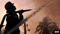  Bomberos cubanos intentan sofocar un incendio 