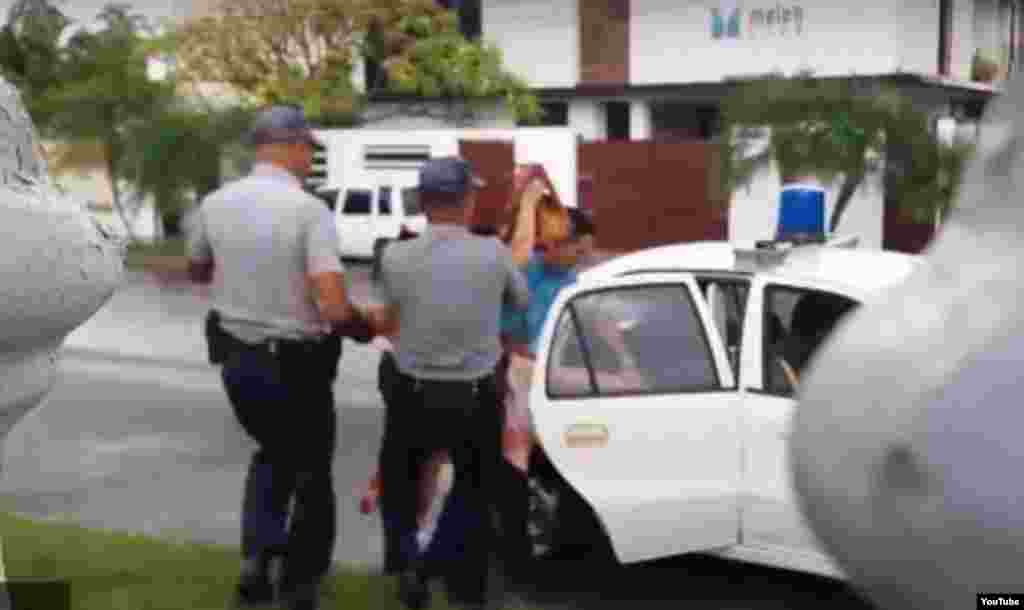 Un agente de la Seguridad del Estado y dos policías arrestan a la activista Ailer González.