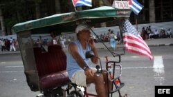 Un cubano exhibe una bandera de EEUU en su bicitaxi, en una calle de La Habana.