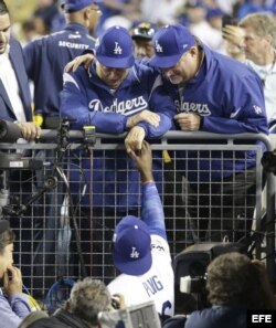 El exmanager de los Dodgers de Los Ángeles Tommy Lasorda (arriba) y el jardinero derecho cubano Yasiel Puig (abajo) se saludan después que los Dodgers derrotaran a los Astros de Houston durante el sexto juego de la Serie Mundial de Grandes Ligas (MLB).