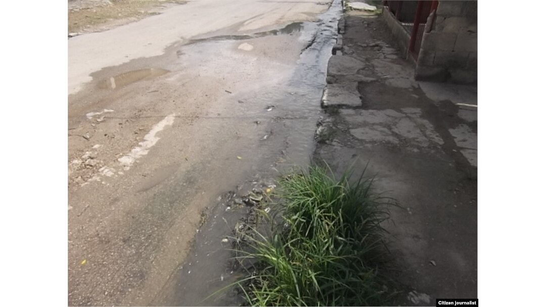 Calle abajo, el agua sucia se desplaza por San Miguel del Padrón.