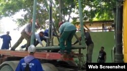 Trabajadores cubanos intentan reparar las lámparas dañadas.