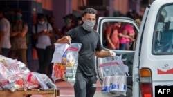 Un trabajador carga el 17 de junio en una furgoneta paquetes de compras hechas por internet en La Habana (Yamil Lage/AFP).