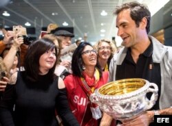 Roger Federer (d) saluda a sus seguidores junto a su trofeo del Abierto de Australia a su llegada al aeropuerto de Zúrich (Suiza).