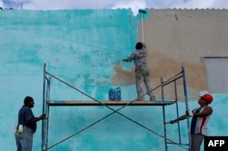 Trabajadores cubanos pintan una pared en La Habana en abril de 2018, cuando Miguel Díaz Canel asumió como gobernante designado por Raúl Castro.
