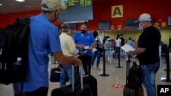 Pasajeros hacen fila en el mostrador de Copa Airlines en el Aeropuerto Internacional José Martí, en La Habana. (YAMIL LAGE / AFP)