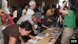 Varios jóvenes indocumentados soñadores rellenan folletos y reciben información de unos voluntarios el 2 de julio 2012, durante un foro comunitario celebrado en Tucson, Arizona. 