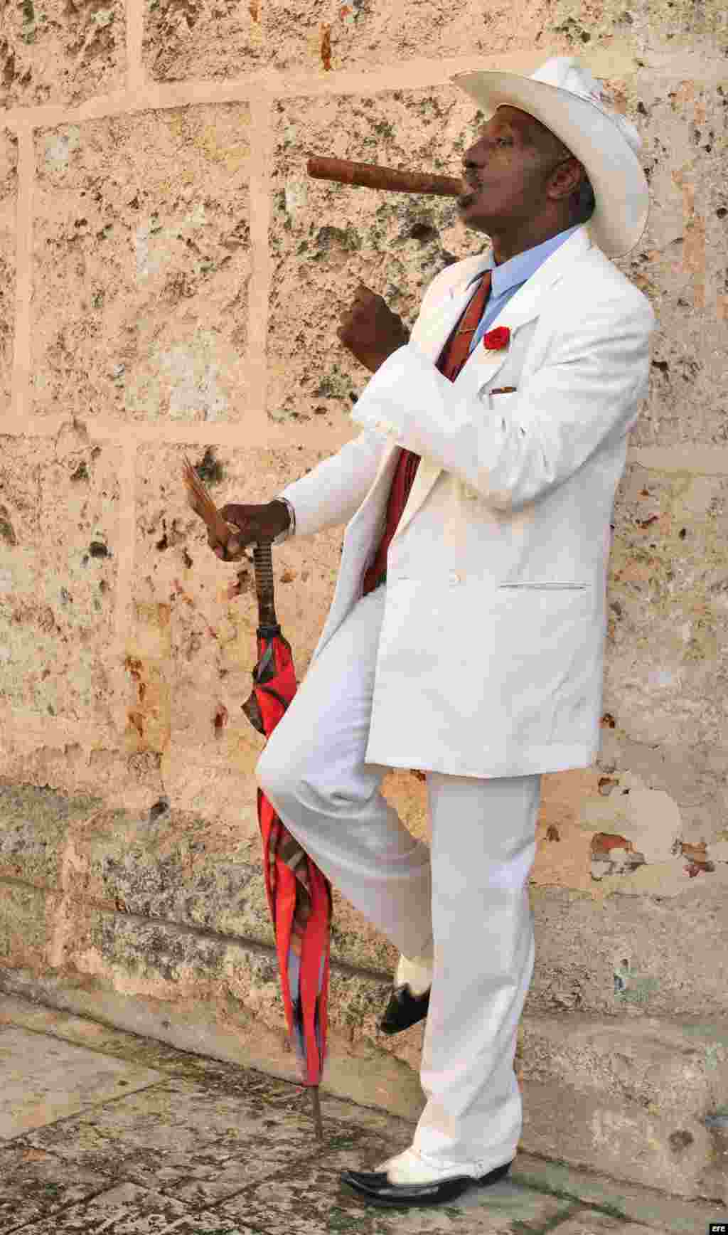 Archivo 2010 - Rafael, de 63 años, que ejerce de "elegante" en el entorno de la Catedral de La Habana. Cartomántica, pelador de frutas, peluquera de trenzas y hasta "dandy" son algunos de los singulares oficios que pueden ejercer de forma privada los cuba