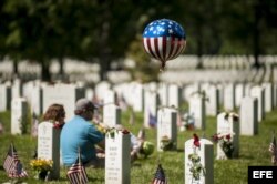 Varias personas visitan tumbas de familiares en el Cementerio Nacional de Arlington