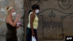 Dos mujeres caminan el martes por una calle de La Habana usando máscaras para evitar la propagación del coronavirus (Foto: Yamil Lage/AFP).