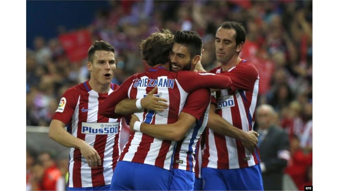 El delantero belga del Atlético de Madrid, Yannick Carrasco (2ºd), recibe la felicitación de sus compañeros tras marcar su tercer gol ante el Granada.