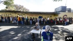 Venezolanos en una cola para comprar alimentos distribuidos por los Comités Locales de Abastecimiento y Producción (CLAP), promovidos por el gobierno de Venezuela. AFP/ Matias Delacroix.