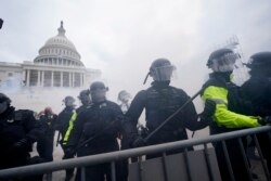 Partidarios de Trump intentan atravesar una barrera policial en el Capitolio de Washington. (AP/Julio Cortez)