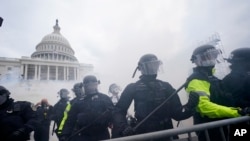 Partidarios de Trump intentan atravesar una barrera policial en el Capitolio de Washington. (AP/Julio Cortez).