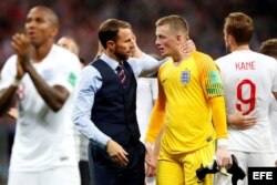 El técnico de Inglaterra Gareth Southgate (c-i) consuela al portero inglés Jordan Pickford (c-d) tras el partido Croacia-Inglaterra.