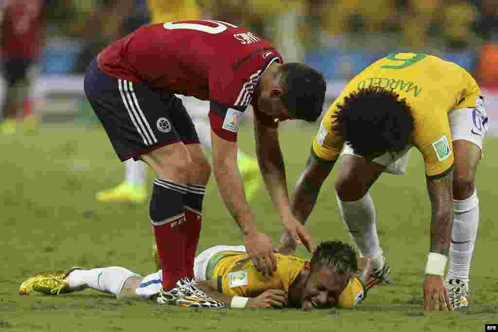 Neymar (c) es atendido por su compañero Marcelo (d) y el centrocampista colombiano James Rodríguez (i) tras recibir un golpe 
