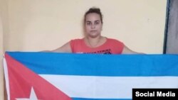 Irina León Valladares, de la Fundación Vueltabajo por Cuba, portando el estandarte nacional bajo la campaña "La bandera es de todos". (Facebook).