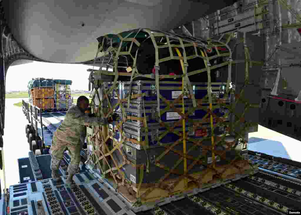 Miembro de las FFAA de EEUU transportando ayuda humanitaria a un avión que partirá a Nepal .