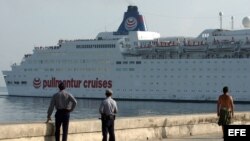 Dos policías observan la entrada de un crucero turístico en la bahía de La Habana./ Foto de archivo