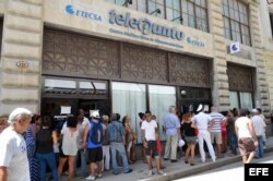 Varias personas hacen fila para ingresar a un telepunto y contratar el servicio de correo para sus teléfonos móviles en La Habana.