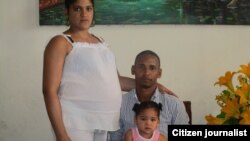 Yamilka Abascal, embarazada de 8 meses, y Rolando Casares, junto a una de las hijas del matrimonio.