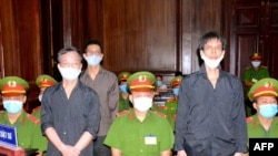 Los blogueros Pham Chi Dung (derecha), Nguyen Tuong Thuy (izquierda, atrás) y Le Huu Minh Tuan (izquierda) en un juicio el 5 de enero de 2021 en Vietnam. (STR/Vietnam News Agency/AFP).