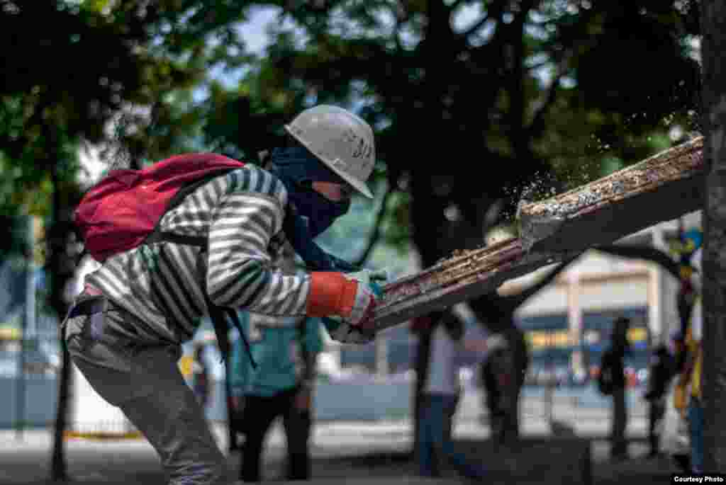 Manifestantes destruyen bancos de cemento ubicados en el bulevar en Chacaito para sacar trozos pequeños de cemento y lanzarlos a efectivos de la PNB. (Foto: Juan Pablo Arraez)